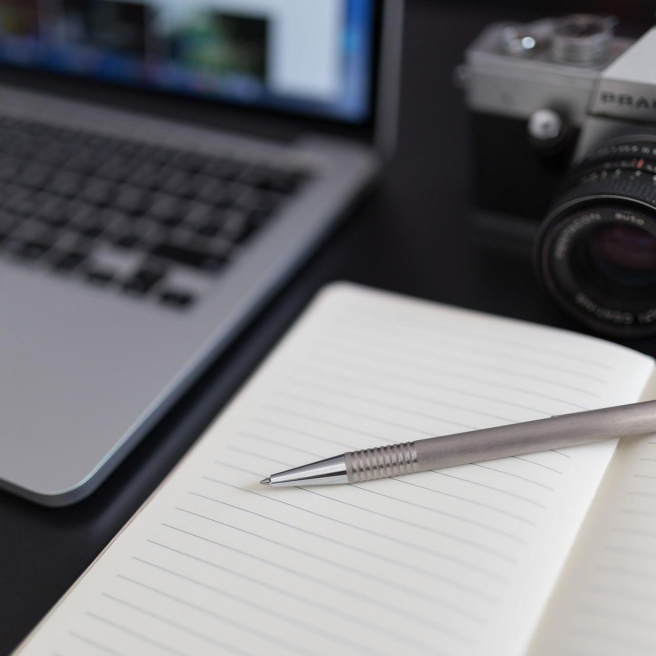 Laptop, Notizbuch und Kamera