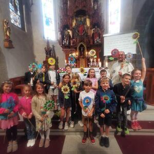 Nun dürfen die Kinder ihre Blumen wieder mit nach Hause nehmen, und der Blumentrog vor dem Altar wird abgebaut.