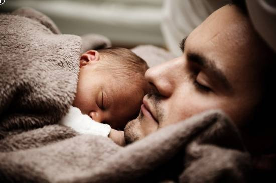 Vater kuschelt mit seinem Baby